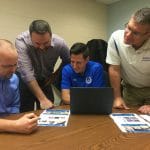 Clay Showalter, Mike Stoltzfus, Andrew Gascho and Dave Bechler review plans for the athletics section of the website, one of the most visited parts of the school's site.