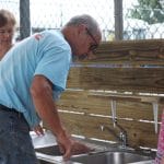 Volunteer Fred Miller builds an outdoor playground learning sink