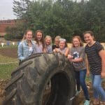 Middle school science classes help install tires in playground.