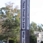 The peace pole in front of the school's upper building carries a message of peace in many languages.