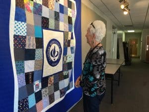 Dorothy Logan looks at the Centennial Quilt that she helped design and stitch