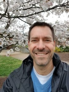 Paul Leaman, head of school, is one of the few people able to enjoy the blossoms outside the school building