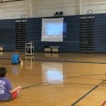 Seventh grade PE class includes a rotation in the gym for physically distanced yoga exercises.