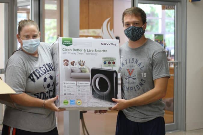 Jennifer Young and Zach Sauder begin to unpack air purifying technology for classrooms during COVID-19 distance learning