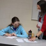 Trisha Blosser, development officer, with a student during Christmas Fund Drive letter writing
