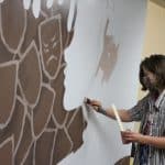 Anneke McDonald '22 paints a mural backstage