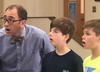 Mr. Stutzman sings with two middle school boys.